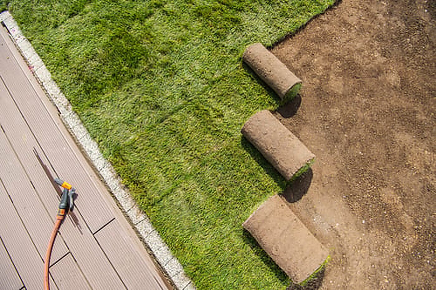 Turf rolls staged on a prepared decomposed granite base during an artificial turf installation